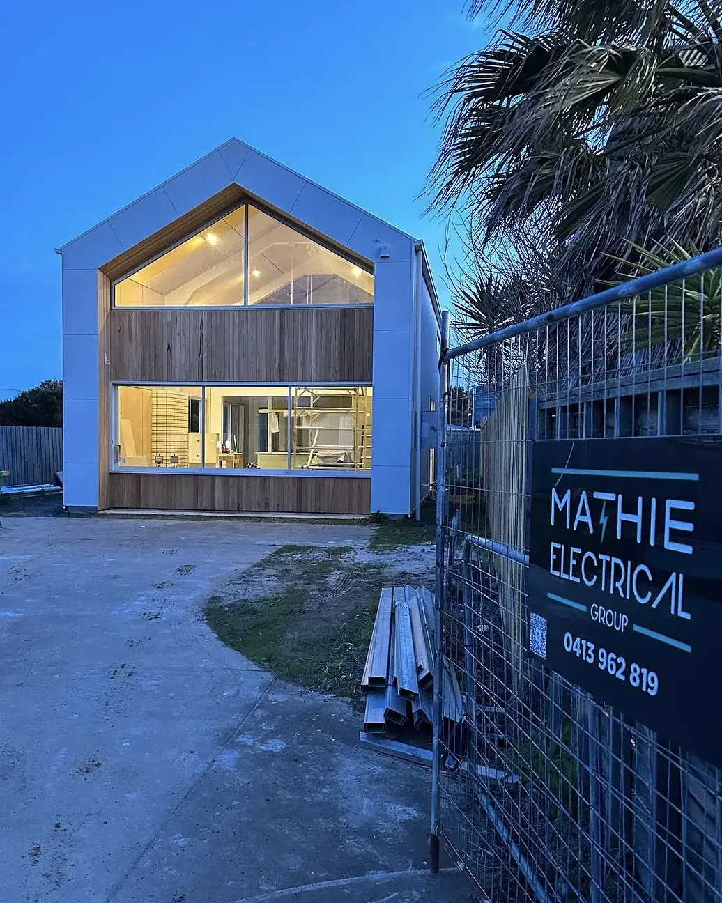 Architectural new build lit up at dusk, Phillip Island - full electrical fit-off by Mathie Electrical